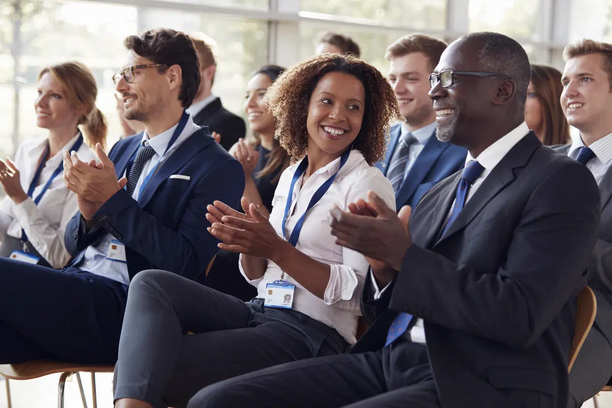 People applauding at conference — benefits compliance certification and training event