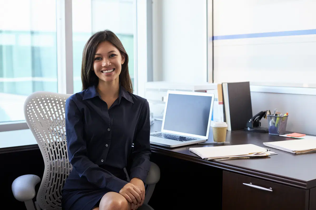 Businesswoman at desk with laptop — benefits enrollment review and administration