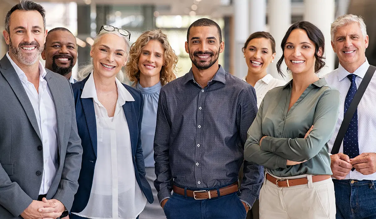 Group of employees smiling — HR team kickoff for benefits enrollment season